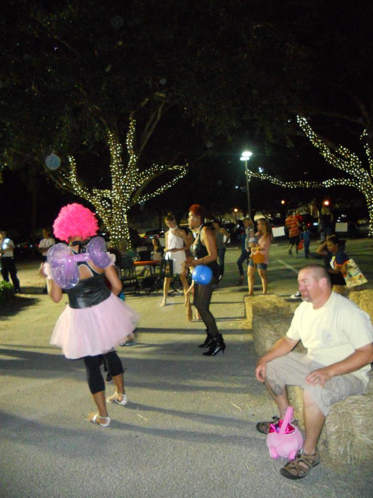 People in Halloween costumes dance in street